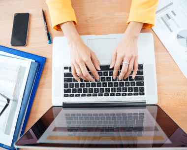 Close-up of female hands typing on a laptop, representing comprehensive typing solutions for documents in all formats.