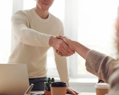 A digital typing expert is shaking hands with his client after the deal.